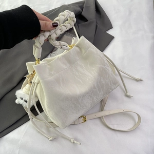 Sac seau plissé blanc cassé avec poignée tressée et breloque pelucheuse chic