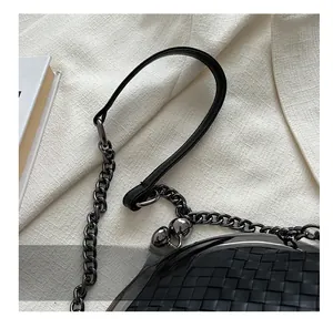 Close-up of woven leather shell bag featuring metal chain and spherical clasp detail
