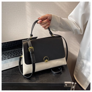 Fashionable black and white color-block handbag with gold ring buckle and shoulder strap