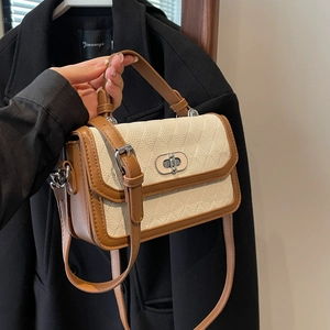 Chic quilted crossbody bag in cream and brown contrast with metal twist lock closure