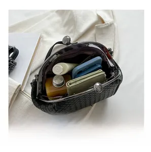 Detail view showing large interior capacity of black woven crossbody bag with daily items