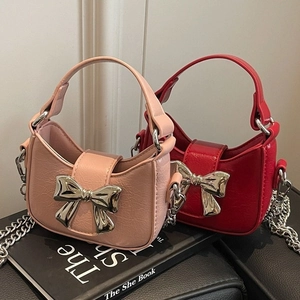 Chic mini bow shoulder bags in pink and red with silver chain straps on book