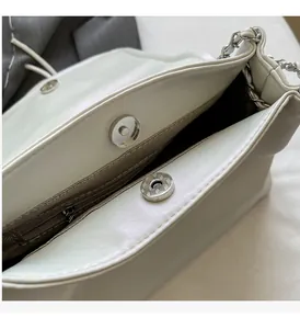 Dettaglio borsa crema con trama a pieghe ondulate e chiusura magnetica in metallo argento