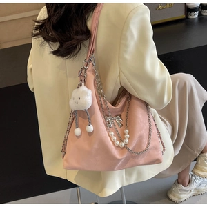 Détail du sac Hobo rose avec chaînes argentées, nœud et mascotte nuage doux