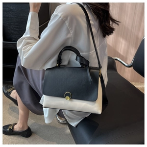 Detail of color-block leather handbag with golden ring buckle and slim shoulder strap