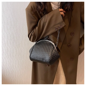 Close-up of black woven leather clutch bag with silver metal clasp and chain strap