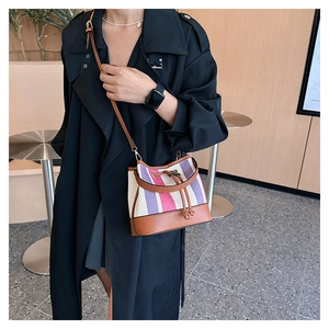Dettaglio della borsa a secchiello a righe color-block con chiusura a coulisse in pelle
