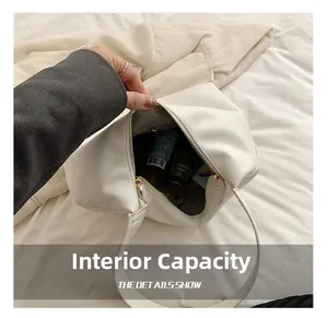 Top view of white leather shoulder bag showing spacious interior and metal zipper detail