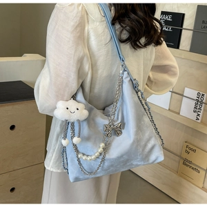 Détail du sac fourre-tout bleu clair en velours avec nœud argenté et chaîne de perles