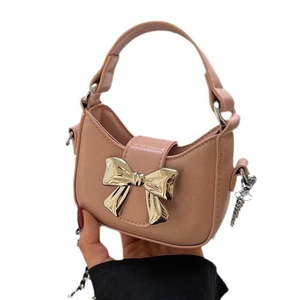Pink half-moon chain bag with large gold bow detail and versatile leather handle
