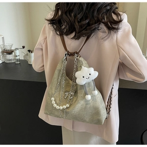 Detail of sage green textured shoulder bag with pearl chain and smiley cloud charm