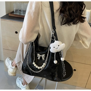 Détail du sac Hobo en similicuir noir avec chaîne argentée et breloque en perles
