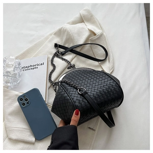 Detail of black woven leather texture and silver chain strap on shell cloud handbag