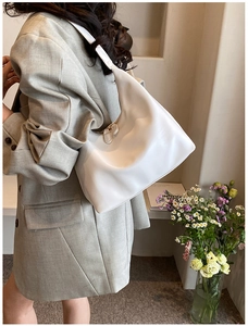 Minimalist white hobo shoulder bag styled on model with a sleek modern design