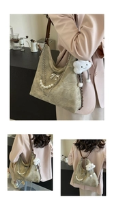 Close-up of khaki suede hobo bag featuring pearl chain and metal bow detail