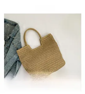 Détail du tissage en paille kaki naturelle et de l'ouverture en U sur ce sac de plage