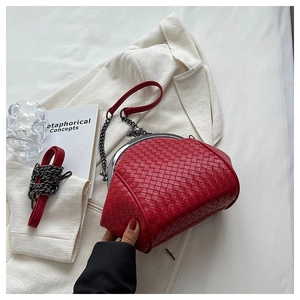 Close-up of red woven leather shell bag with vintage metal kiss-lock and chain strap