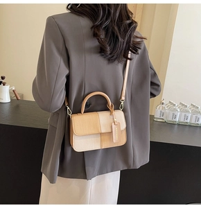 Detail of color-block plaid square bag with a fashion tag and slim shoulder strap