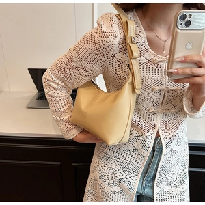 Detail of cream beige hobo bag with a decorative bow strap and smooth faux leather