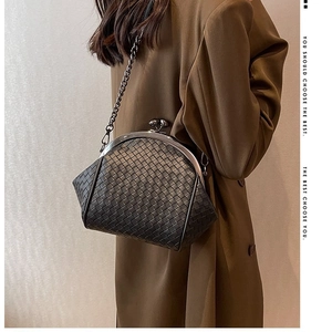 Gray woven shell bag with vintage metal clasp and chain strap worn over long brown coat