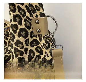 Close-up of leopard jacquard tote with silver lobster clasp and khaki leather strap