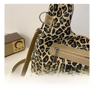 Detailed close-up of leopard print tote bag featuring smooth silver zipper and leather strap
