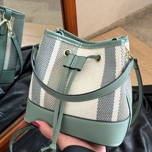 Borsa a secchiello a righe bianche e verdi con coulisse e tracolla in pelle verde moda