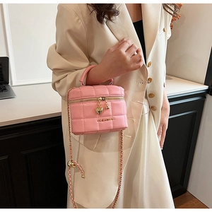 Détail du sac à main matelassé rose avec pendentif cœur et chaîne dorée pour femme