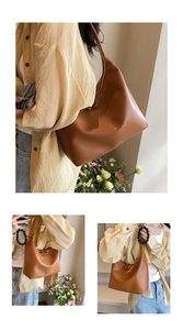Detail of caramel hobo bag with gold zipper and stylish black beaded tassel charm