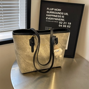 Retro grey large tote bag with black straps and cute plush pendant on metal stand