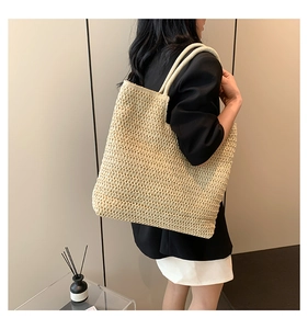 Détail d'un grand sac cabas en paille tressée avec poignées robustes pour la plage d'été