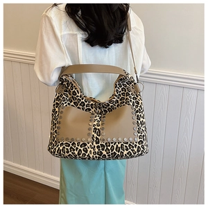 Detailed back view of a large leopard print tote bag with rivets on shoulder strap