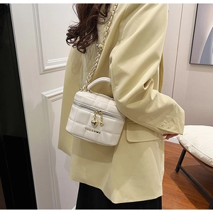 Détail du sac à bandoulière en cuir matelassé blanc avec chaîne dorée et cœur