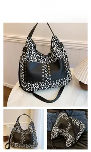 Detail of leopard print tote bag featuring black leather pockets and silver studs