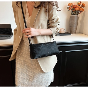 Close-up of vintage black faux leather shoulder bag with a textured finish and mini logo