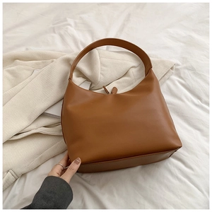 Caramel vintage leather hobo bag on neutral textured background for women