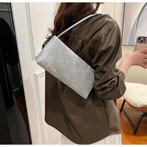Detail of silver metallic handbag with pearl finish and BLEAROK logo in modern style