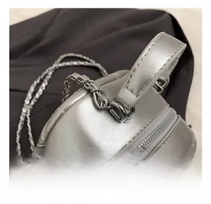 Detail of silver metallic quilted backpack featuring premium metal chain and zipper