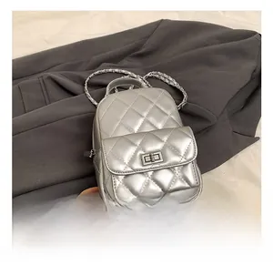 Detail showing the quilted silver metallic leather texture and silver chain strap on bag