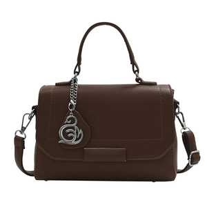 Dark brown textured leather handbag with silver swan pendant and adjustable strap