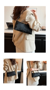 Close-up of minimalist black rectangle shoulder bag with vintage leather texture for women