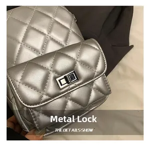 Close-up of silver quilted texture and metallic turn-lock closure on the mini backpack