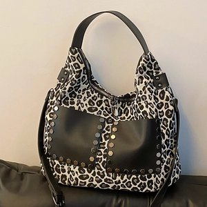 Leopard print canvas tote bag with black leather pockets and adjustable strap