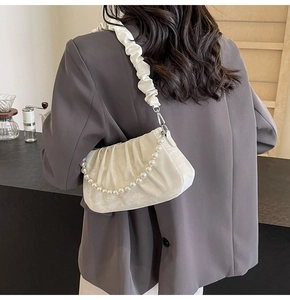 Détail du sac à bandoulière blanc plissé avec chaîne de perles et bandoulière froncée