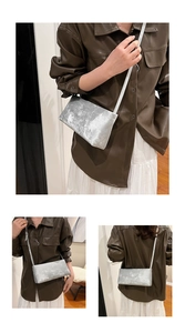 Three-way view of a silver metallic rectangle shoulder bag with foil texture and slim strap