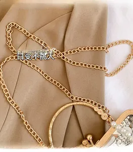 Nahaufnahme der goldenen Kette mit silbernen Pailletten und Perlendetail auf Luxustasche