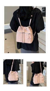 Detail of pink crinkled leather bucket backpack with silver chain and drawstring
