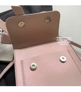 Detail of pink leather bag showing double magnetic buckle closure and front pocket