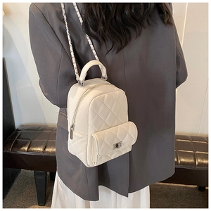 Close-up of white quilted mini backpack featuring silver twist lock and chain strap