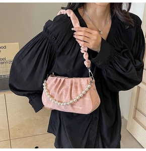 Détail d'un sac nuage plissé rose avec chaîne en perles et bandoulière froncée